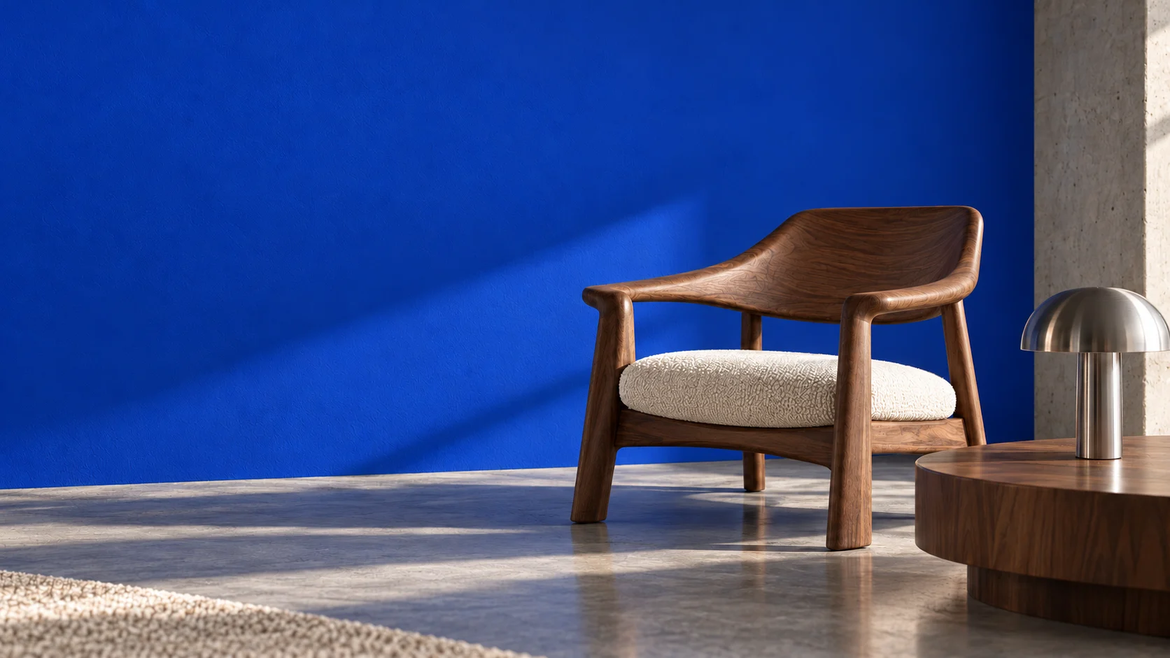 Sculptural walnut chair and brushed steel lamp against a cobalt wall